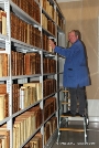 Der Leiter des Stadtarchivs, Dr. Dirk Schleinert, hat sichtlich Freude daran, die zurückgekehrten Buchschätze aus der Archivbibliothek in die Regale einzuordnen.